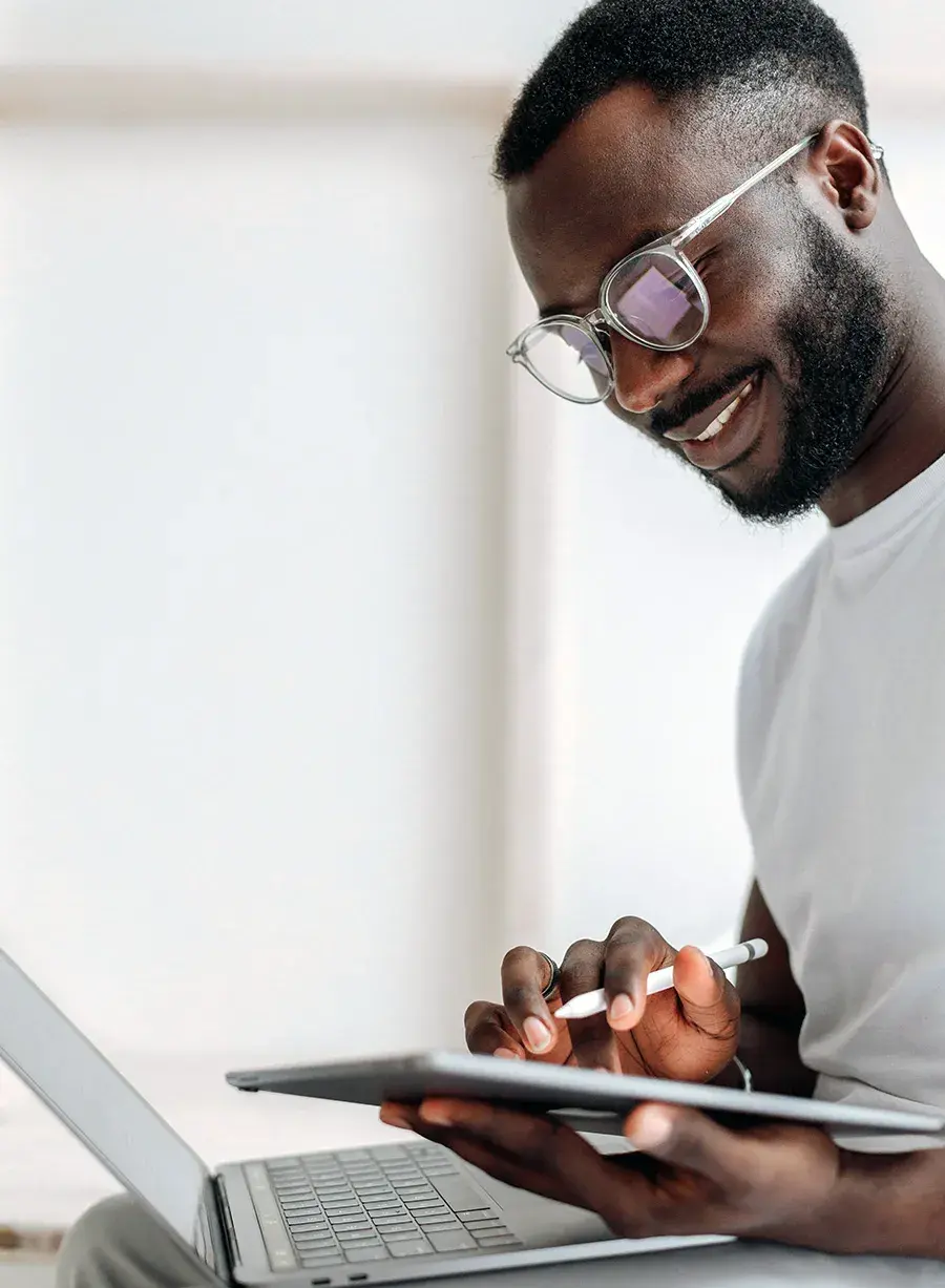 Man working on tablet and laptop